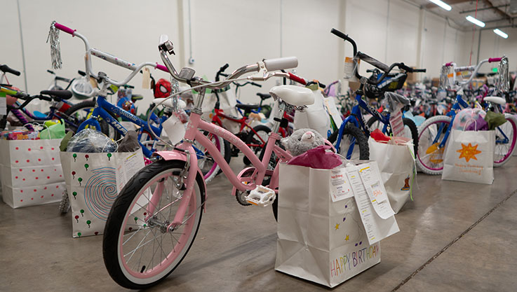 A photo of children's bikes parked with birthday gift bags next to them. 