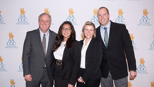 Photo of the Elan team in front of the AACUC step and repeat banner.