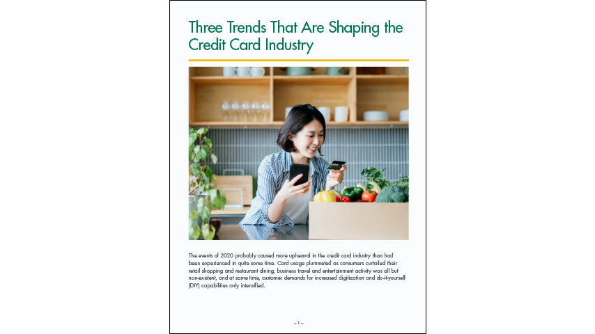 A woman stands in her kitchen with a box of groceries in front of her on the counter. She's holding a cell phone and credit card. Text reads "Three Trends That Are Shaping The Credit Card Industry"